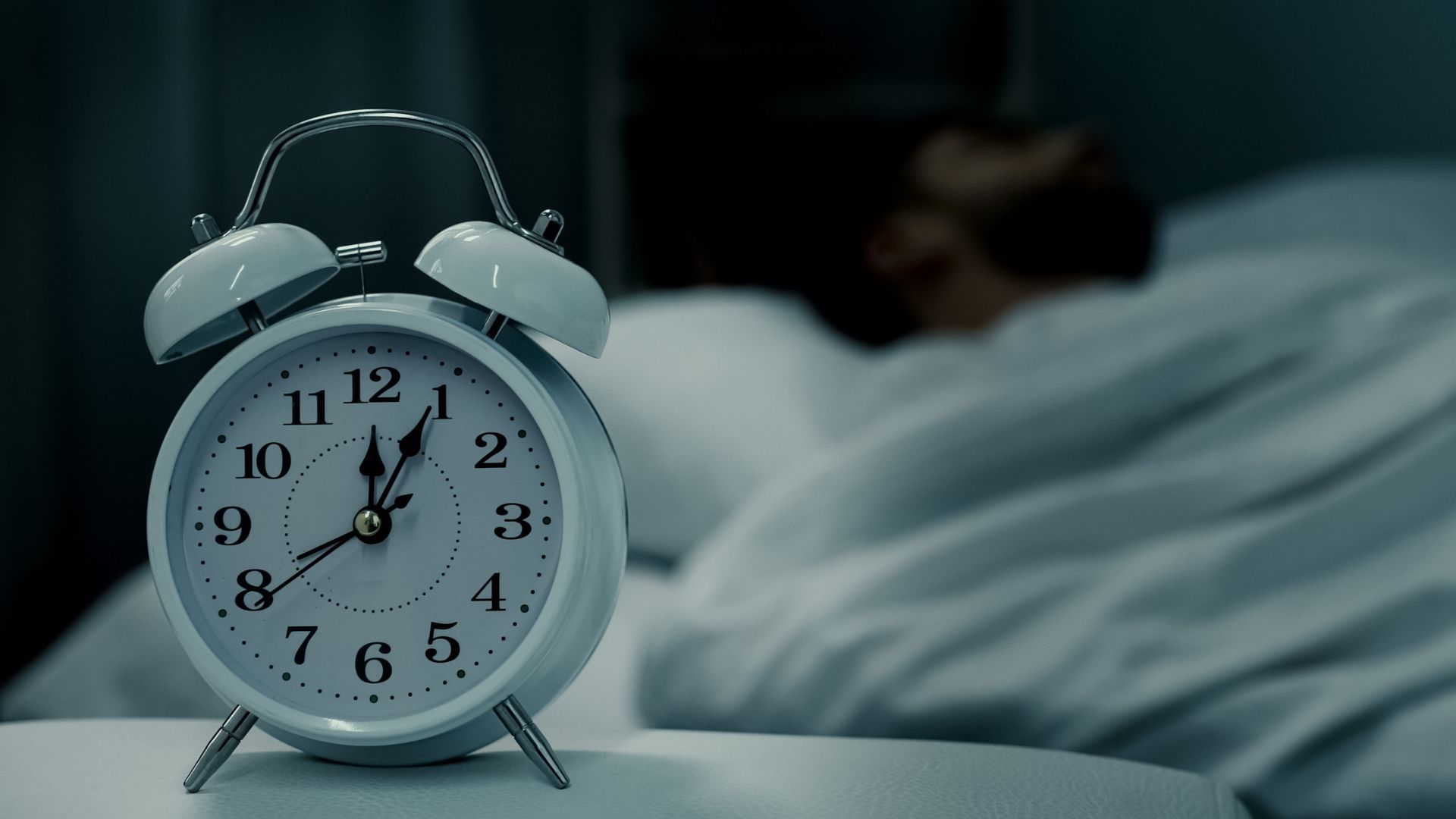 Image illustrant la thématique du sommeil, avec un réveil et une personne dormant en arrière-plan, symbolisant les actions de prévention du sommeil proposées par ISBA Santé.